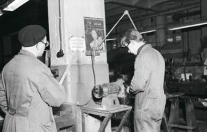 Hyvässä perehdytyksessä huomioidaan myös työturvallisuusasiat. Kesällä 1955 työnjohtaja opastaa turvallista työskentelyä Osuustukkukaupan korjaamolla Helsingissä.