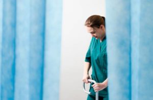 Liisa-Lotta Heinonen visar hur man kan justera de nya sjukhussängarna så att patienterna får optimalt stöd då de ska ta sig upp ur sängen.