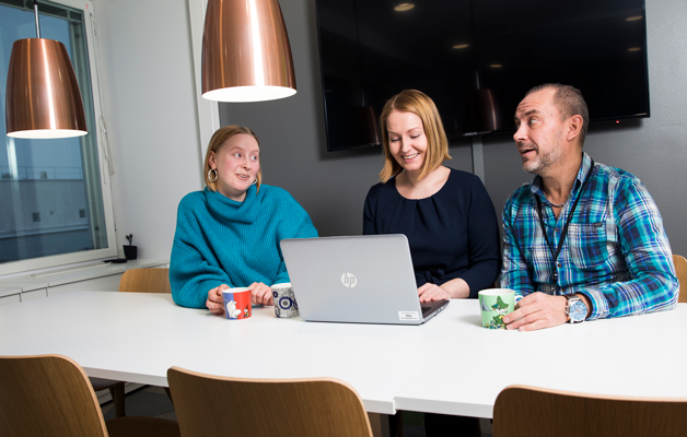 Tilda Lindgren, Mari Kauranen och Anssi Roivainen trivs i det gemensamma kafferummet på arbetsplatsen.