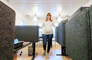 Toimitusjohtaja Suvi Hassinen korostaa ergonomian merkitystä työhyvinvoinnissa. Toimistossa on säädettävät työpöydät.